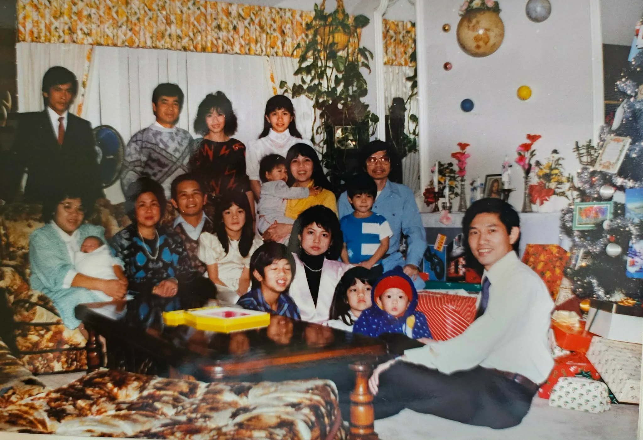 A large multigenerational family group photographed together in a living room.